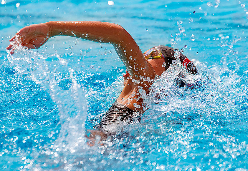 student swimming for her school swim team