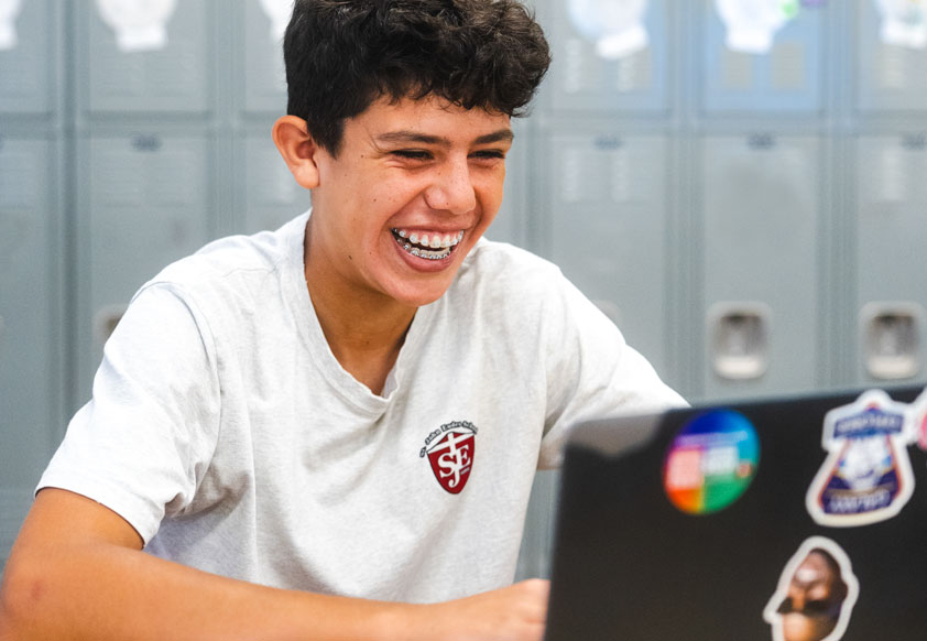 student in class using laptop