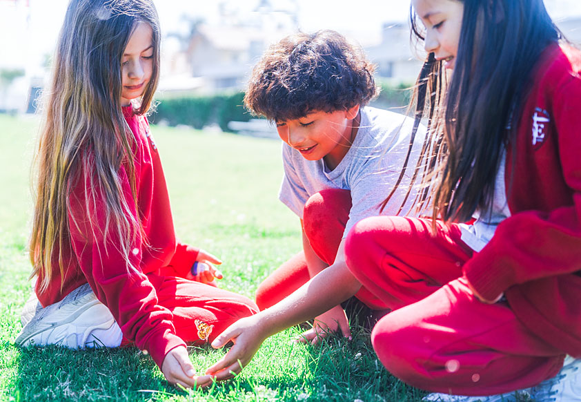 SJE-Giving Three school kids sitting on the lawn
