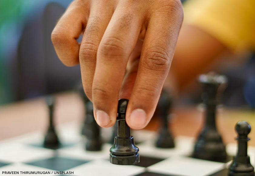 chess-club Child's hand moving a chess piece